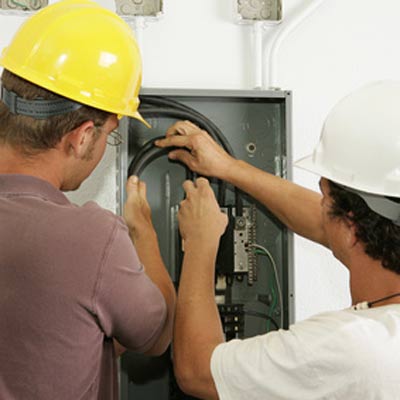 electricians working on electrical panel